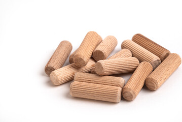 Pile of wooden dowels on the white background.