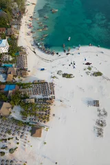 Photo sur Plexiglas Plage de Nungwi, Tanzanie Aerial view of the fishing boats and umbrellas on tropical sea coast with sandy beach.Summer travel in Zanzibar, Africa.Top view of boats and clear green water.