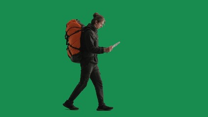 A male tourist studies a map of the area while hiking. A man traveler in full length with a...