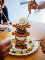 Waffle topped with cream and ice cream. chocolate, caramel and honey syrup with ice cream scoop...