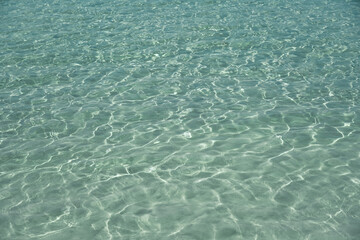 Detail of a sunlight reflecting in glittering sea. sparkler in water background. sea water with sun glare and ripple. Powerful and peaceful nature concept. Sea water surface background