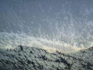 Ice crystals formations on glass car window.
