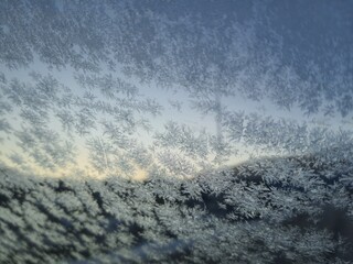 Ice crystals formations on glass car window.