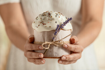 traditional Orthodox Easter cake, in women's hands, close-up on a light background. happy Easter