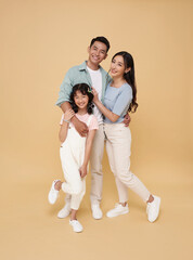 Portrait happy smiling Asian family hugging and love together isolated on nude color background.