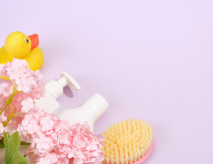 Spring flower arrangement with yellow rubber duck, bathroom products and skin care tools. Copy space for text.