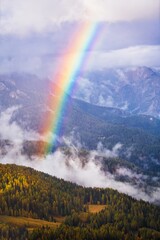 Dolomites Mountains forest and rainbow in autumn season. Italy