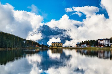 Fototapeta premium Dolomites Mountains and Lake Misurina in autumn season. Bright blue sky with clouds. Italy