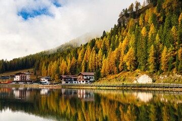 Fototapeta premium Dolomites Mountains and Lake Misurina in autumn season. Bright blue sky with clouds. Italy