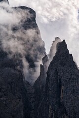 Dolomites Mountains covered in clouds in autumn season.