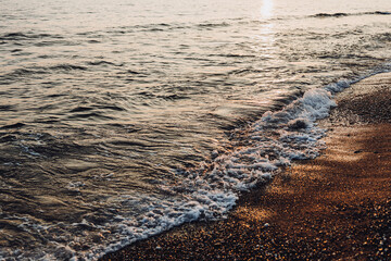 beautiful evening landscape on the sea. sunset of the setting sun. the sun disappeared behind the horizon of the sea.beautiful waves on the sandy beach