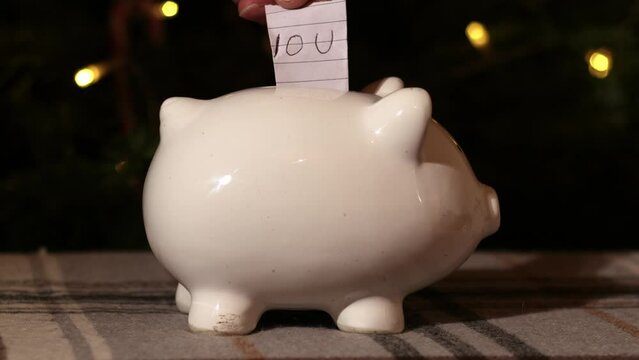 Putting IOU into piggy bank savings in Christmas tree background