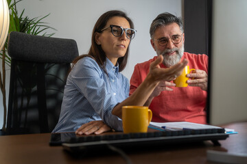 Happy businesspeople working together in the office while using pc computer. Portrait of success business people working together in home office. Couple teamwork startup concept