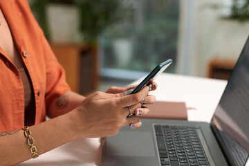 Hands of businesswoman texting colleagues after checking work they did