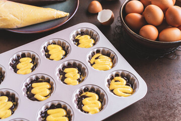 Marble Madeleine batter in a baking tray on rusty table background