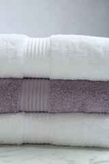 Fototapeta na wymiar Stack of folded terry towels on grey background, closeup