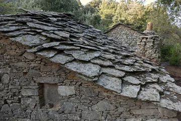 Rolgordijnen Traditional Ikarian old stone house with slate shingles in the quaint mountain village Vrakades, Ikaria, North Aegean islands, Greece © Lars Gieger