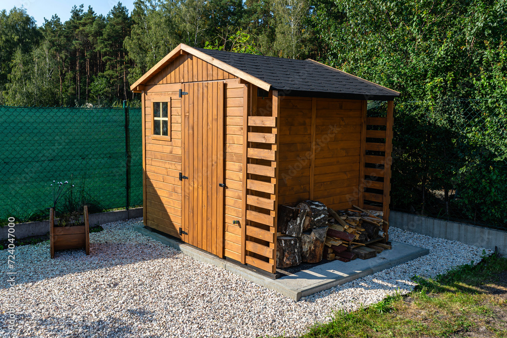 Wall mural A wooden garden shed standing on a concrete foundation in a garden.