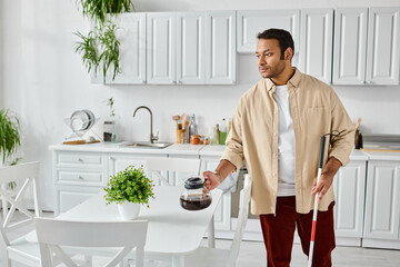 good looking indian man with blindness using walking stick and holding coffee pot while in kitchen