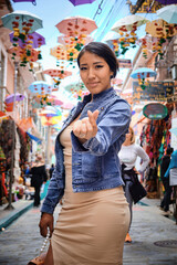 vertical photo beautiful young latina tourist on the streets of la paz making a heart with her hand...