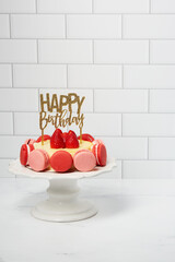 Birthday French Macarons Cheesecake with fresh strawberries on white marble and subway tile