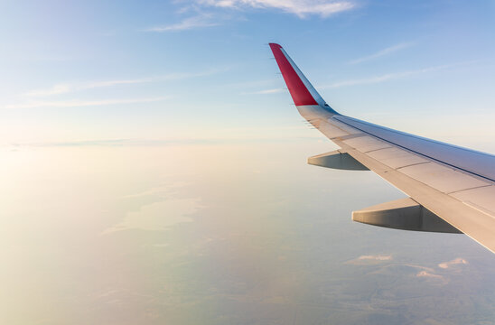 View from the airplane window at a beautiful cloudy sky and the airplane wing