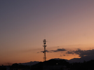 Communication and nature: the beauty of a sunset behind an antenna: a photo that combines technology and landscape in a harmonious and colorful scene.