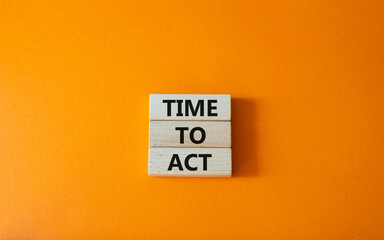 Time to Act symbol. Wooden blocks with words Time to Act. Beautiful orange background. Business and...