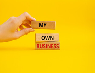 My own Business symbol. Concept words My own Business on wooden blocks. Businessman hand. Beautiful yellow background. Business and My own Business concept. Copy space.