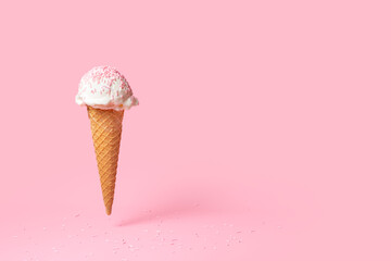 summer funny creative concept of flying wafer cone with ice cream and strewed sprinkles on pink background
