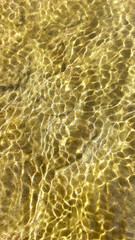 Areia de um riacho sob a luz do Sol