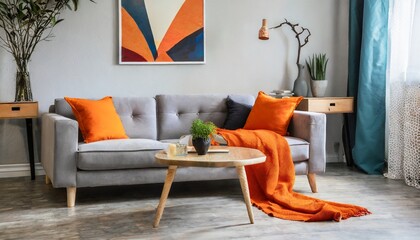 orange blanket on grey sofa in modern apartment interior with poster and wooden table real photo