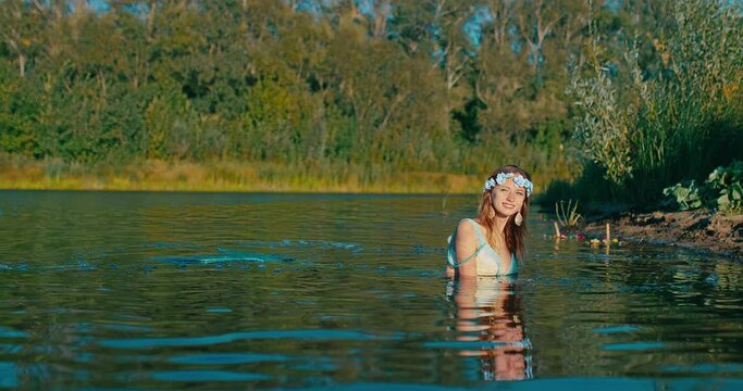 young beautiful rusalka from old Slavic myths lying on shallow of river in summer day, 4K, Prores