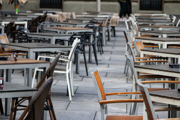 Empty chairs in coffee bar, outdoor seating but empty due to economic crisis and cold winter weather, on the streets of urban metropolis
