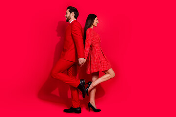 Full body profile photo of two successful idyllic people touch each other back empty space isolated on red color background