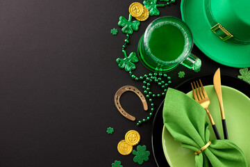 Shamrock splendor: Crafting a stylish St. Paddy's table. Top view shot of plates, cutlery, horseshoe, trefoils, coins, beads, leprechaun hat, green beer on black background with advert area
