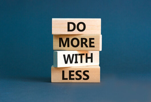 Do more with less symbol. Concept word Do more with less on beautiful wooden block. Beautiful grey table grey background. Business do more with less concept. Copy space.