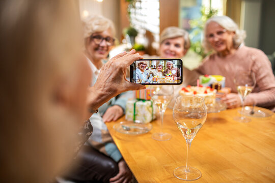 Senior women friends taking a picture with smartphone at home