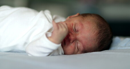 Baby newborn close-up face waking up and opening eyes