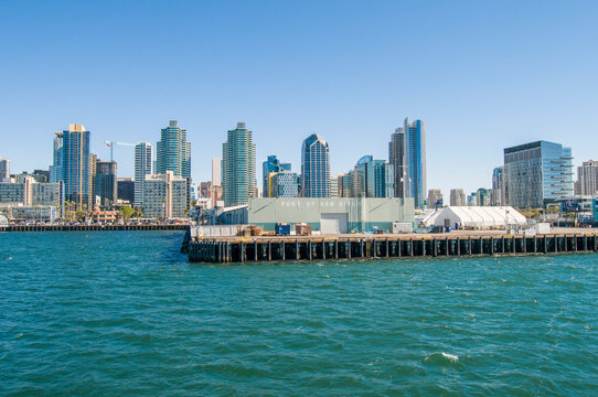 the port of san diego with a view of the city architecture, its buildings and people on a sunny winter day near the uss midway