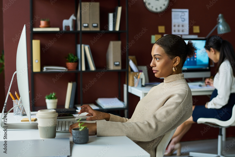 Poster side view of young bored african american businesswoman scrolling through online stuff while looking