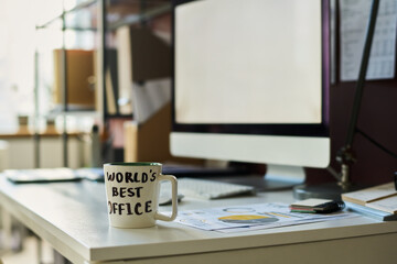 Mug with coffee standing in front of camera on workplace of broker with financial documents against...