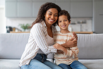 Portrait Of Happy Young Black Mother And Preteen Son Embracing At Home