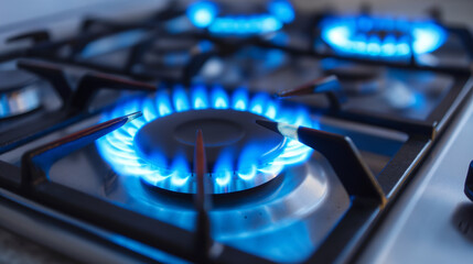 Kitchen stove blue gas burner with gas on. Gas prices, heat and cook with gas - obrazy, fototapety, plakaty