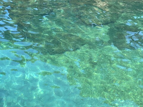 Glittering clear water surface with pebbles at the bottom