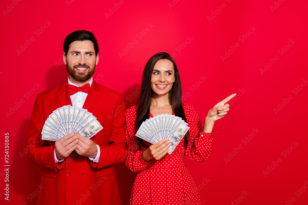 Aufkleber photo of two classy wealthy people hold dollar bills look direct finger empty space isolated on red 
