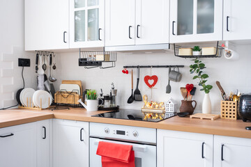 The interior of the kitchen in the house is decorated with red hearts for Valentine's Day. Decor on...