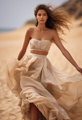 A stylish woman wearing a white sundress gracefully walks along the sandy shoreline of a beautiful beach. - obrazy, fototapety, plakaty