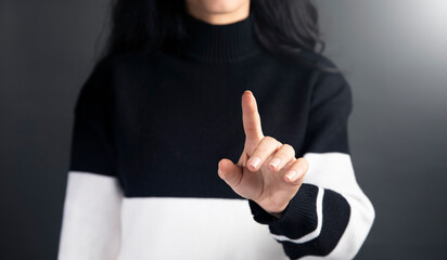 Fototapeta premium a woman in a black and white sweater pointing at something