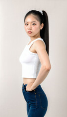 photo of beautiful young asian woman with crop white top and jeans standing at white backdrop, generative AI